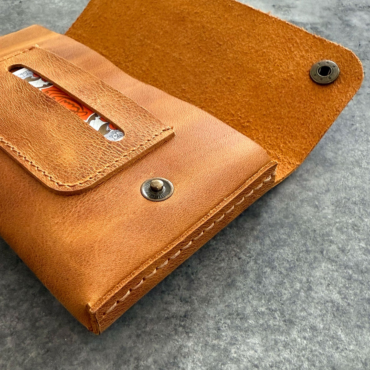El yapımı, camel renkli deri tütün kesesi. Kişisel isim baskısı seçeneğiyle özel bir hediye arayanlar için ideal. Bolt Leather kalitesiyle doğal deri dokusu ve el işçiliği.