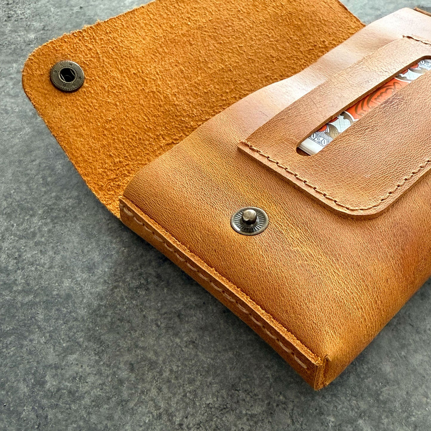 El yapımı, camel renkli deri tütün kesesi. Kişisel isim baskısı seçeneğiyle özel bir hediye arayanlar için ideal. Bolt Leather kalitesiyle doğal deri dokusu ve el işçiliği.