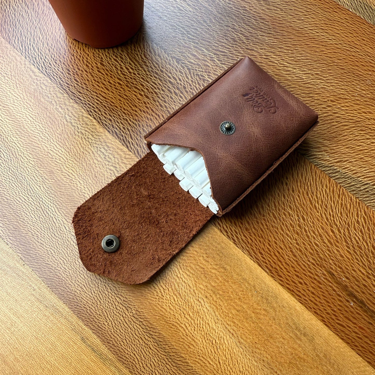 Karton kutulara veda edin, tarzınızı yansıtın.
Sigara keyfinize şıklık ve kalite katacak bu özel deri kutu, sıradan ambalajların çok ötesinde bir deneyim sunar. Artık cebinizden çıkardığınızda sizi yansıtan bir aksesuarla dikkat çekebilirsiniz.