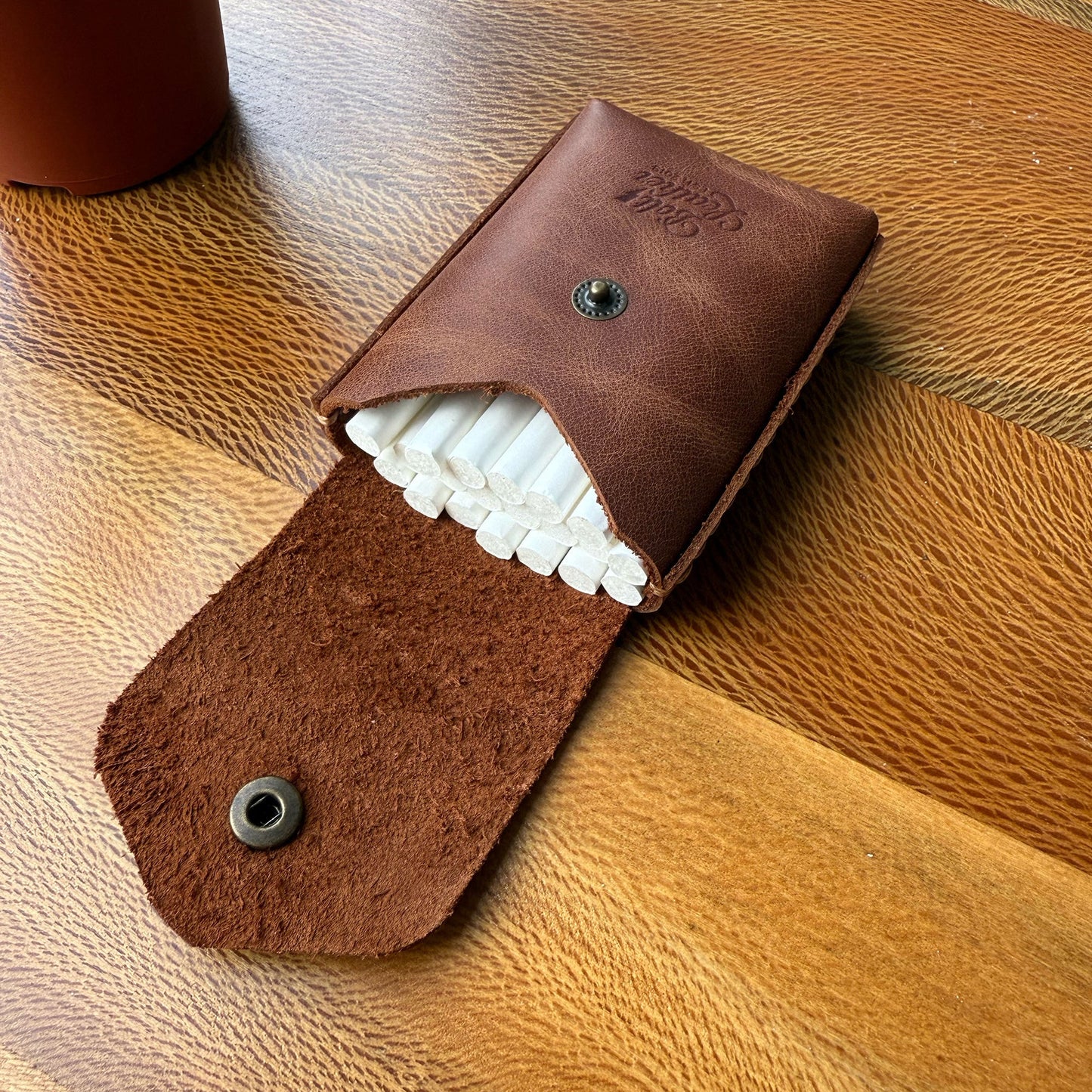 Karton kutulara veda edin, tarzınızı yansıtın.
Sigara keyfinize şıklık ve kalite katacak bu özel deri kutu, sıradan ambalajların çok ötesinde bir deneyim sunar. Artık cebinizden çıkardığınızda sizi yansıtan bir aksesuarla dikkat çekebilirsiniz.