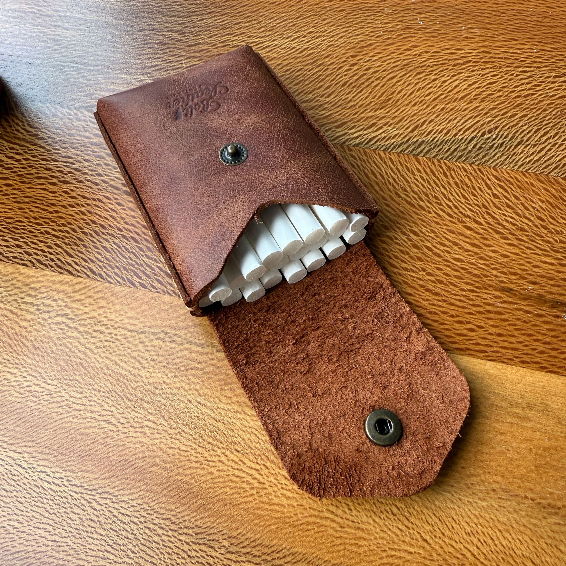 Karton kutulara veda edin, tarzınızı yansıtın.
Sigara keyfinize şıklık ve kalite katacak bu özel deri kutu, sıradan ambalajların çok ötesinde bir deneyim sunar. Artık cebinizden çıkardığınızda sizi yansıtan bir aksesuarla dikkat çekebilirsiniz.