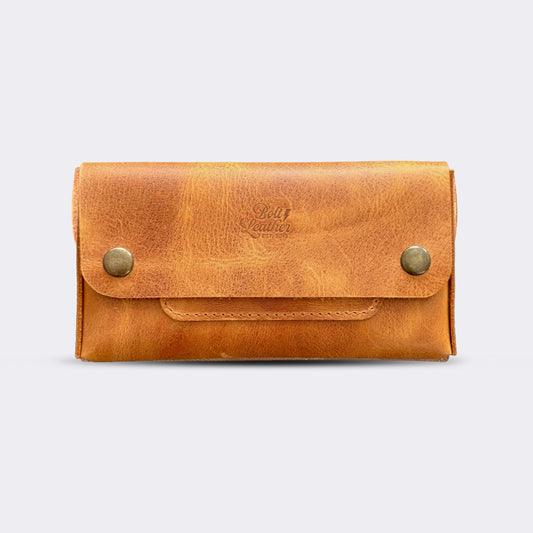 El yapımı, camel renkli deri tütün kesesi. Kişisel isim baskısı seçeneğiyle özel bir hediye arayanlar için ideal. Bolt Leather kalitesiyle doğal deri dokusu ve el işçiliği.